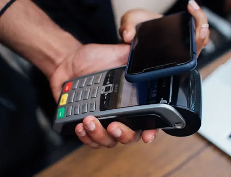 Karta digital credit card used for a contactless tap-to-pay at a LATAM retail point-of-sale terminal — new customer completing their first NFC purchase within minutes of activating the virtual card in the Karta app, before the physical metal card ships