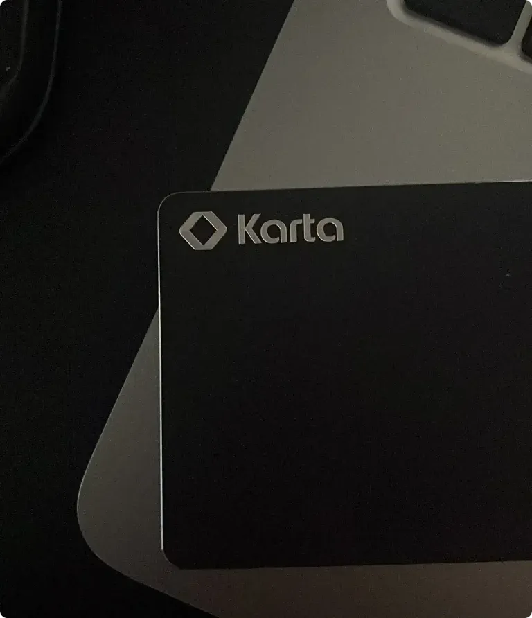 Karta metal card held up in a bright travel moment