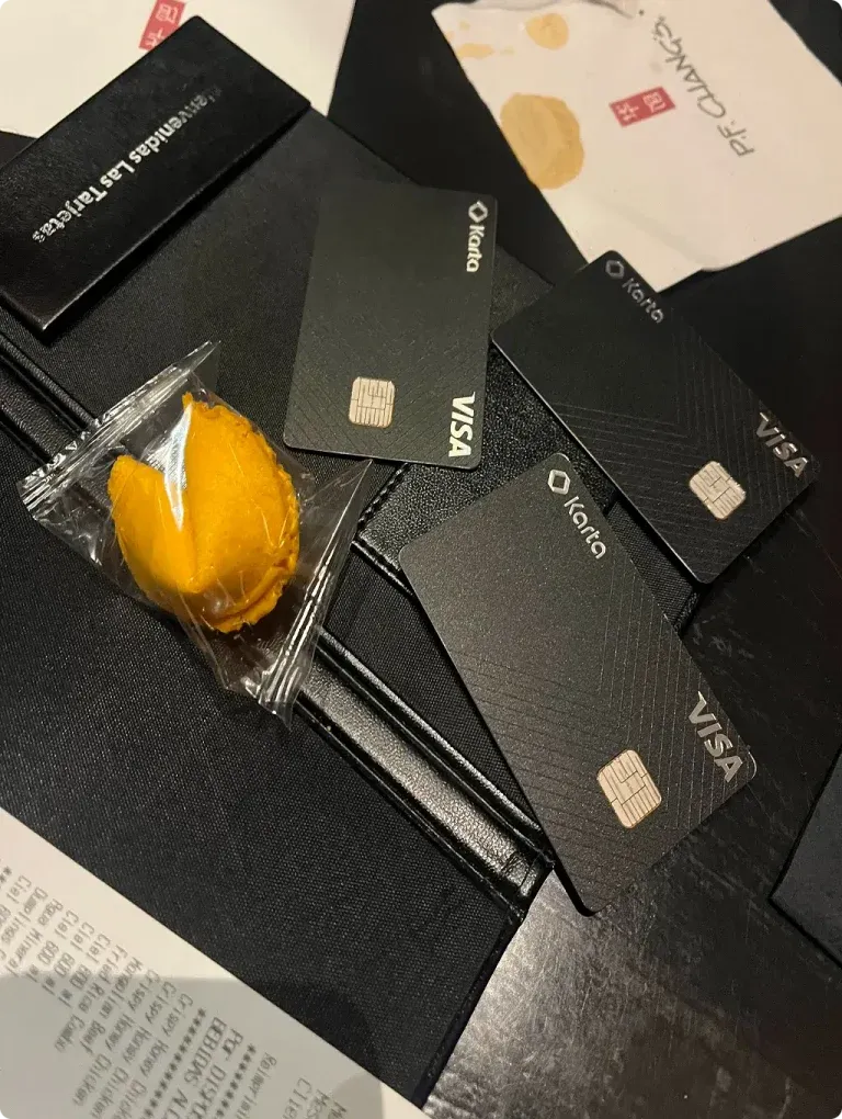 Karta black metal credit card studio close-up — laser-etched Karta wordmark, diamond motif and contactless NFC mark on the heavyweight brushed-metal body, the premium physical product the LATAM high-net-worth customer receives in a signed presentation box after account approval